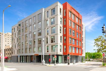 A modern multi-story building with a red and grey facade